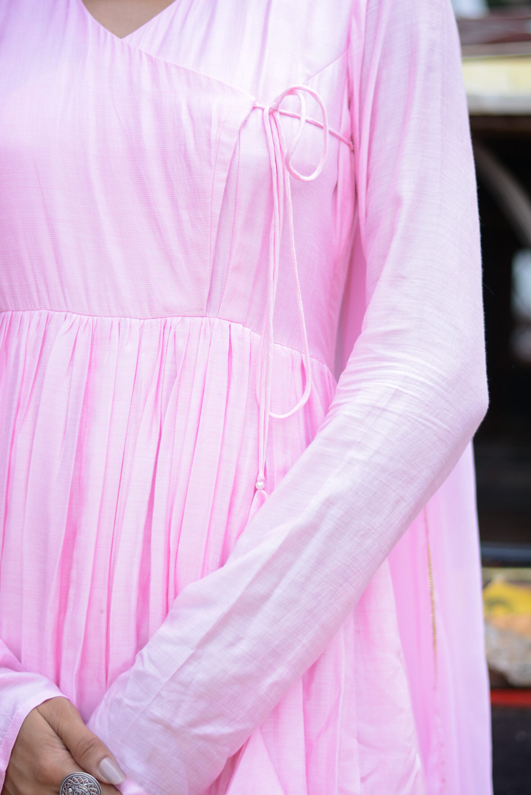 Close-up of a taffy pink anarkali suit set showcasing pleated design and elegant detailing