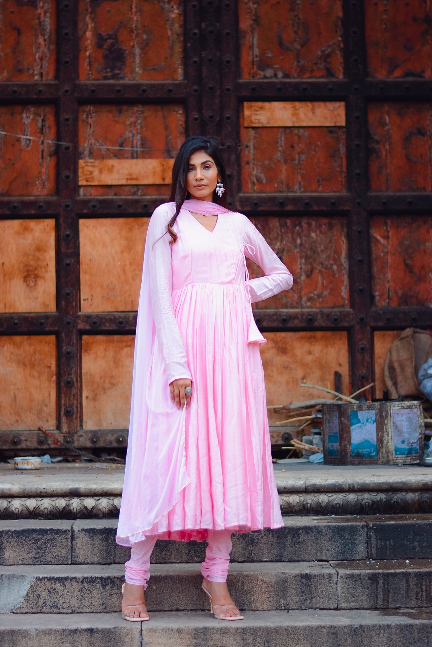 Model wearing a taffy pink anarkali suit set with elegant draping and matching bottoms
