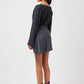 Back view of model wearing Stylera Tate cowl neck dress in black with long sleeves and ankle boots