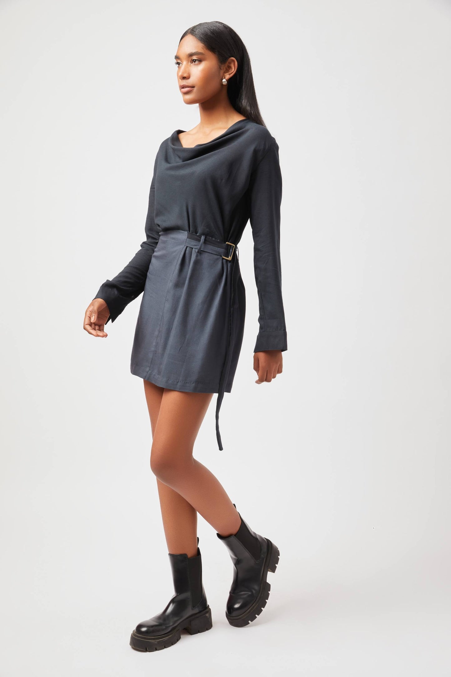 Stylera Tate cowl neck dress in black with long sleeves and belt worn with black boots