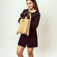 Stylish taupe bucket bag for women by Stylera, held by a model in a black dress