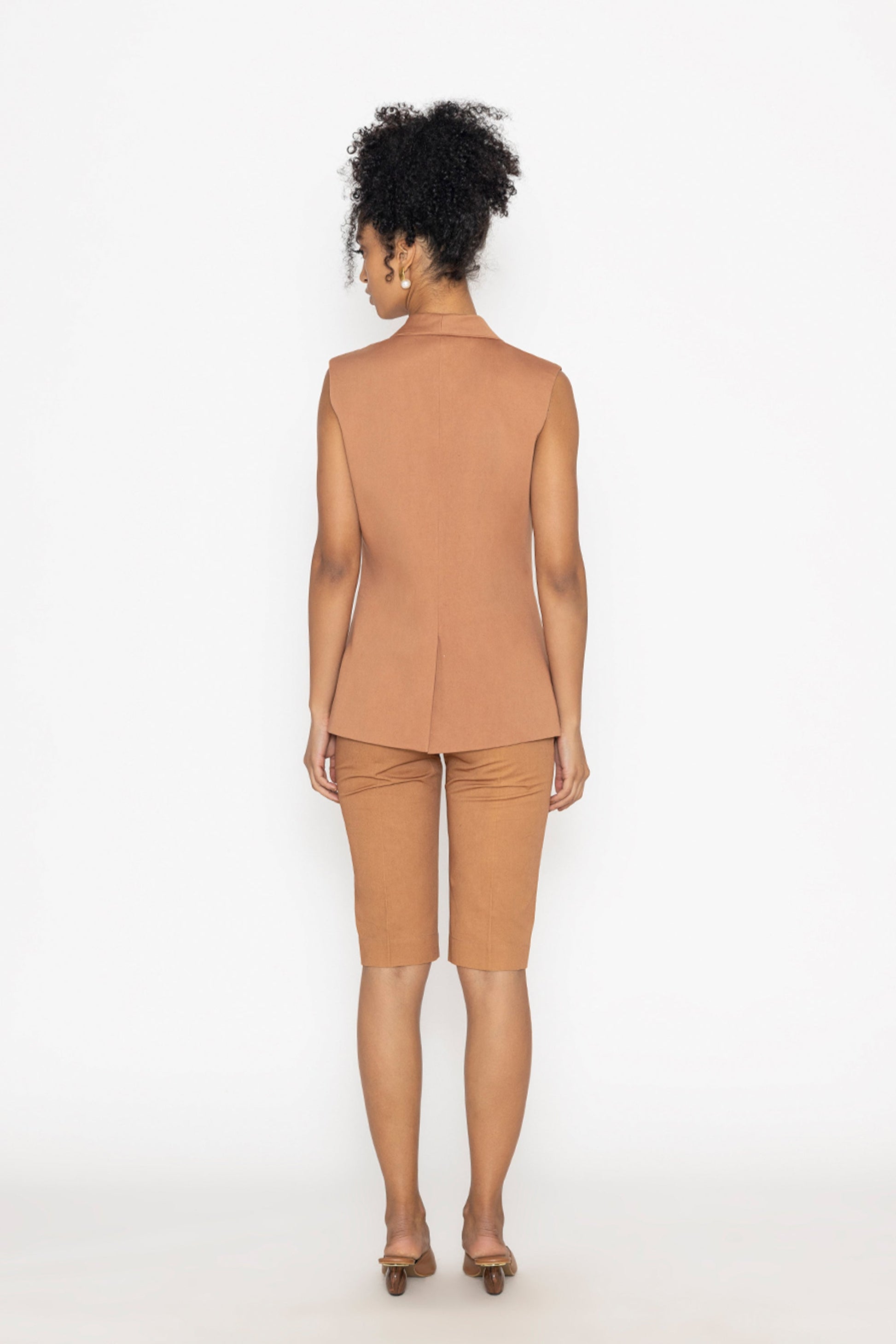 Back view of woman wearing terra color fashion vest and matching shorts by Stylera