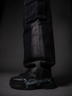 Model posing in wide leg tough jeans streetwear outfit with chunky boots.