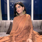 Elegant traditional Anarkali gown caramel with intricate draping and stylish earrings for festive occasions