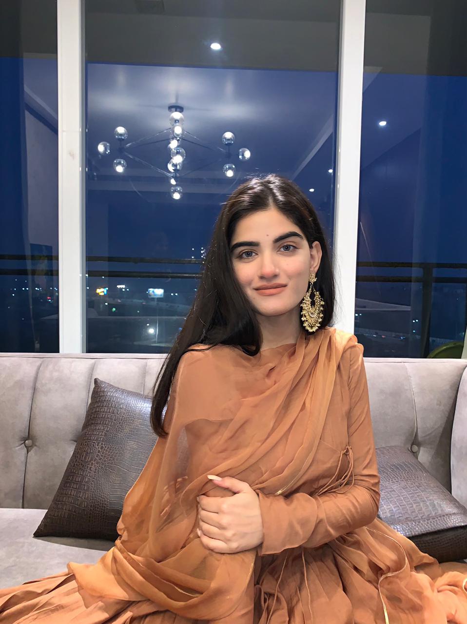 Stylish model in a traditional Anarkali gown caramel, posing elegantly in a modern setting