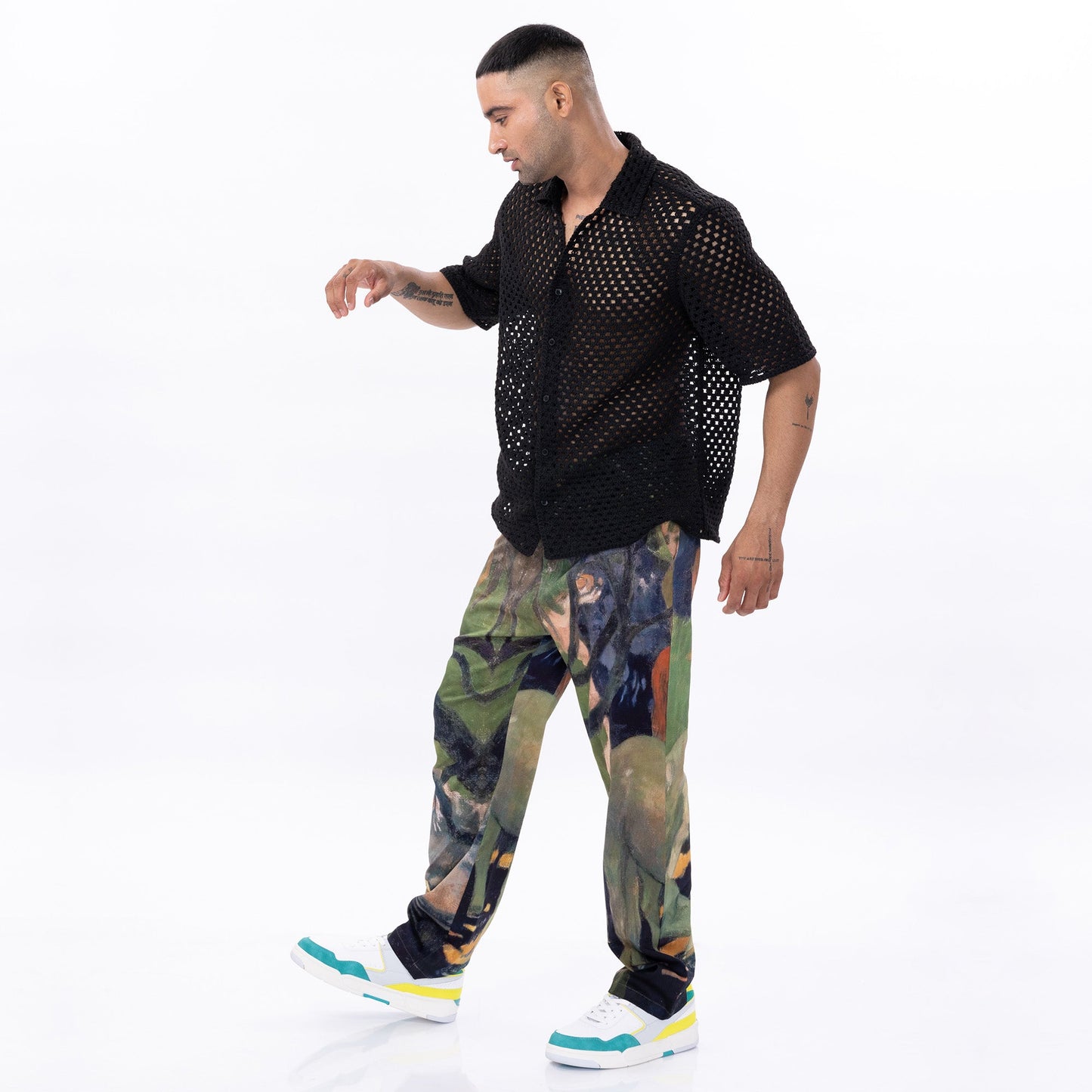 Stylera trendy abstract pattern pants in colorful design, worn by a model with a black shirt and stylish sneakers