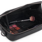 Stylera trendy accessory small black bag open showing makeup brush and eyeshadow palette for travel