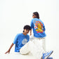 Stylera models wearing trendy blue t-shirt for men and women with bold graphic back print and white pants