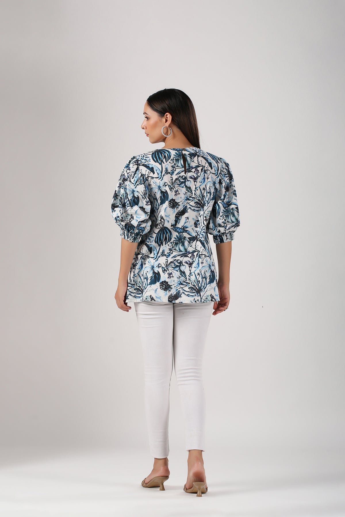 Back view of a stylish Stylera trendy casual tops for women featuring a vibrant floral design and puff sleeves