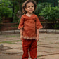 Cute child wearing a trendy children's ethnic outfit in rust color with detailed embroidery