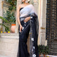 Elegant woman wearing a trendy elegant party wear saree in black with floral embroidery outdoors