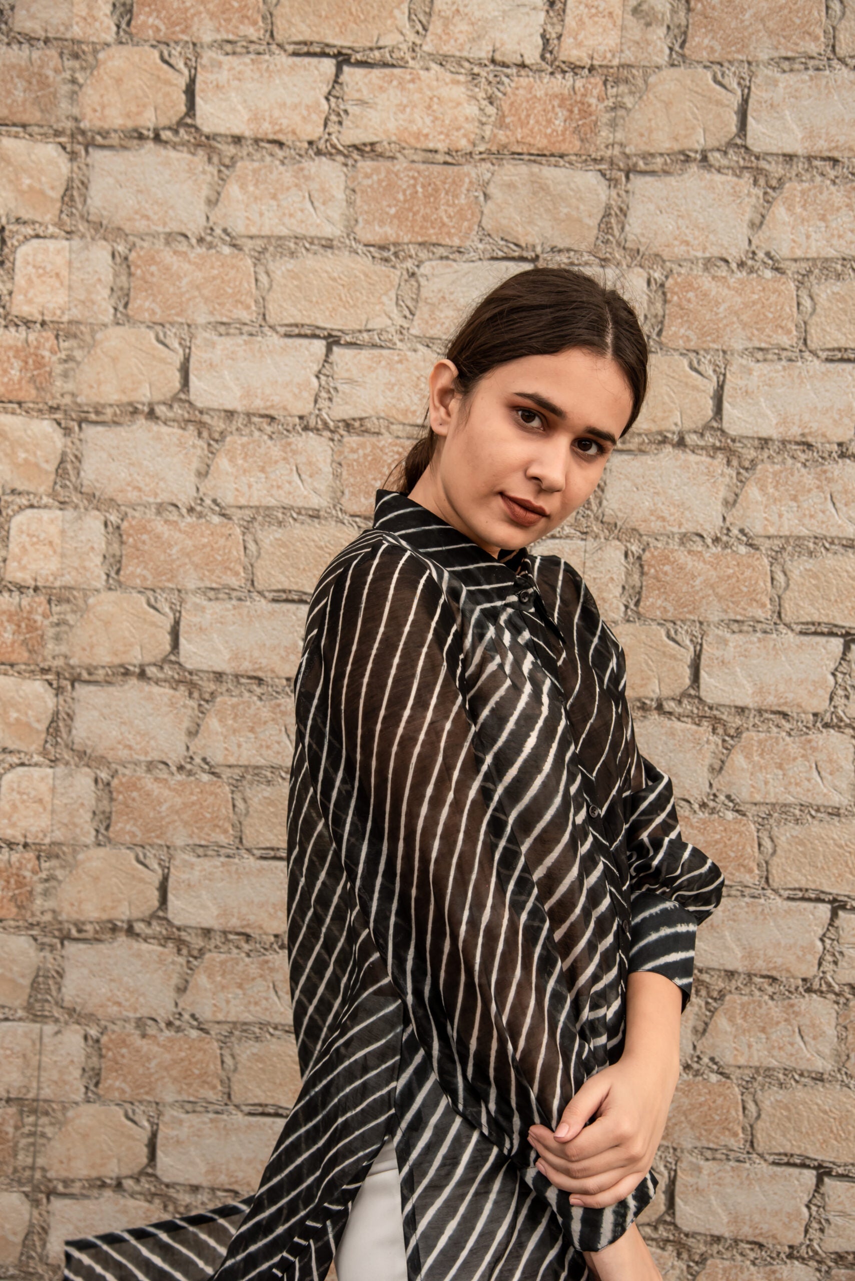 Stylish Stylera's trendy ethnic wear for women with black and white stripes against a brick wall