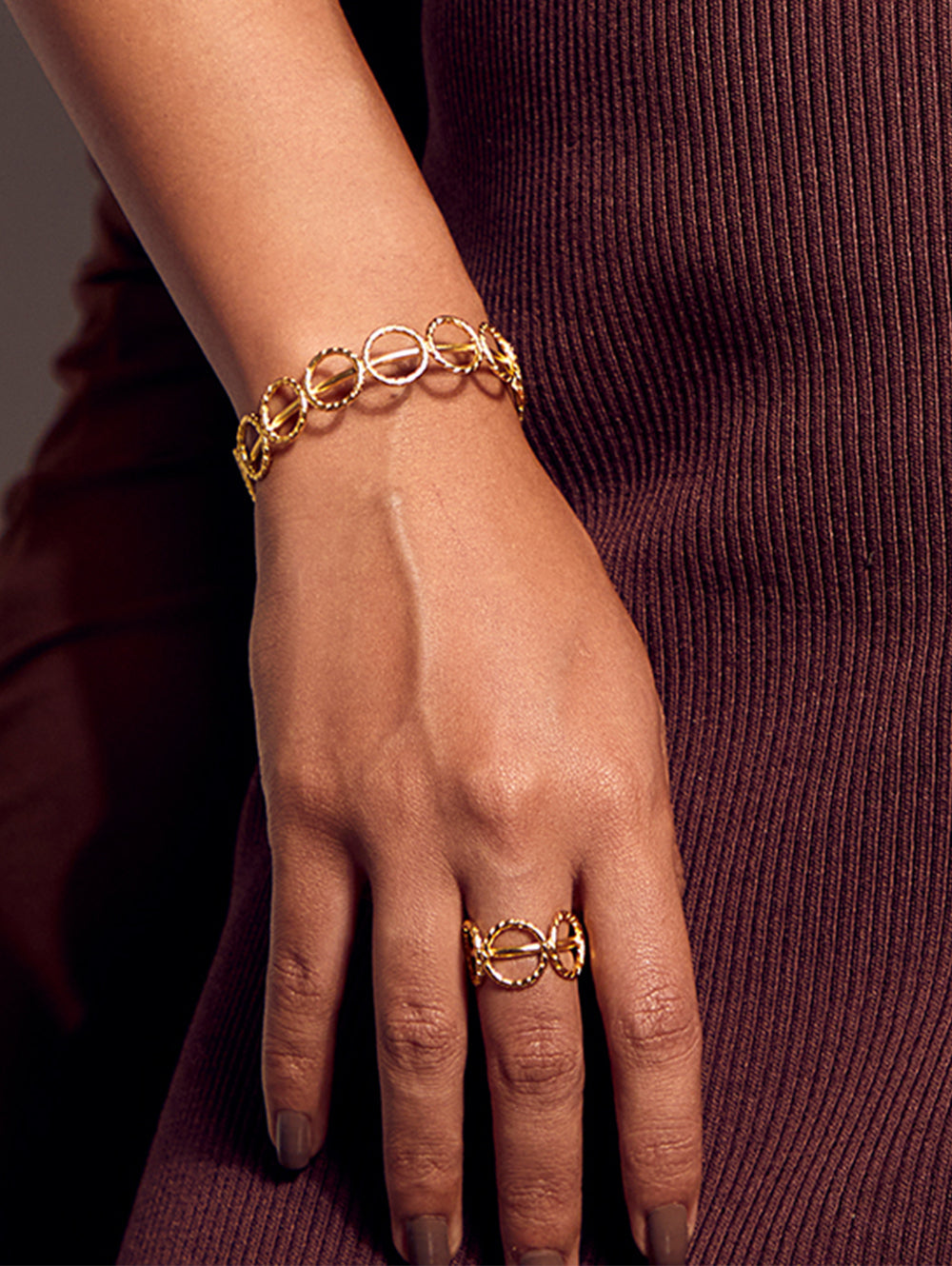 Stylera trendy gold accessory bracelet with linked circle design worn with matching ring