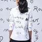 Stylera white shirt with handwritten black graphics and clover motif back view trendy graphic shirts for women
