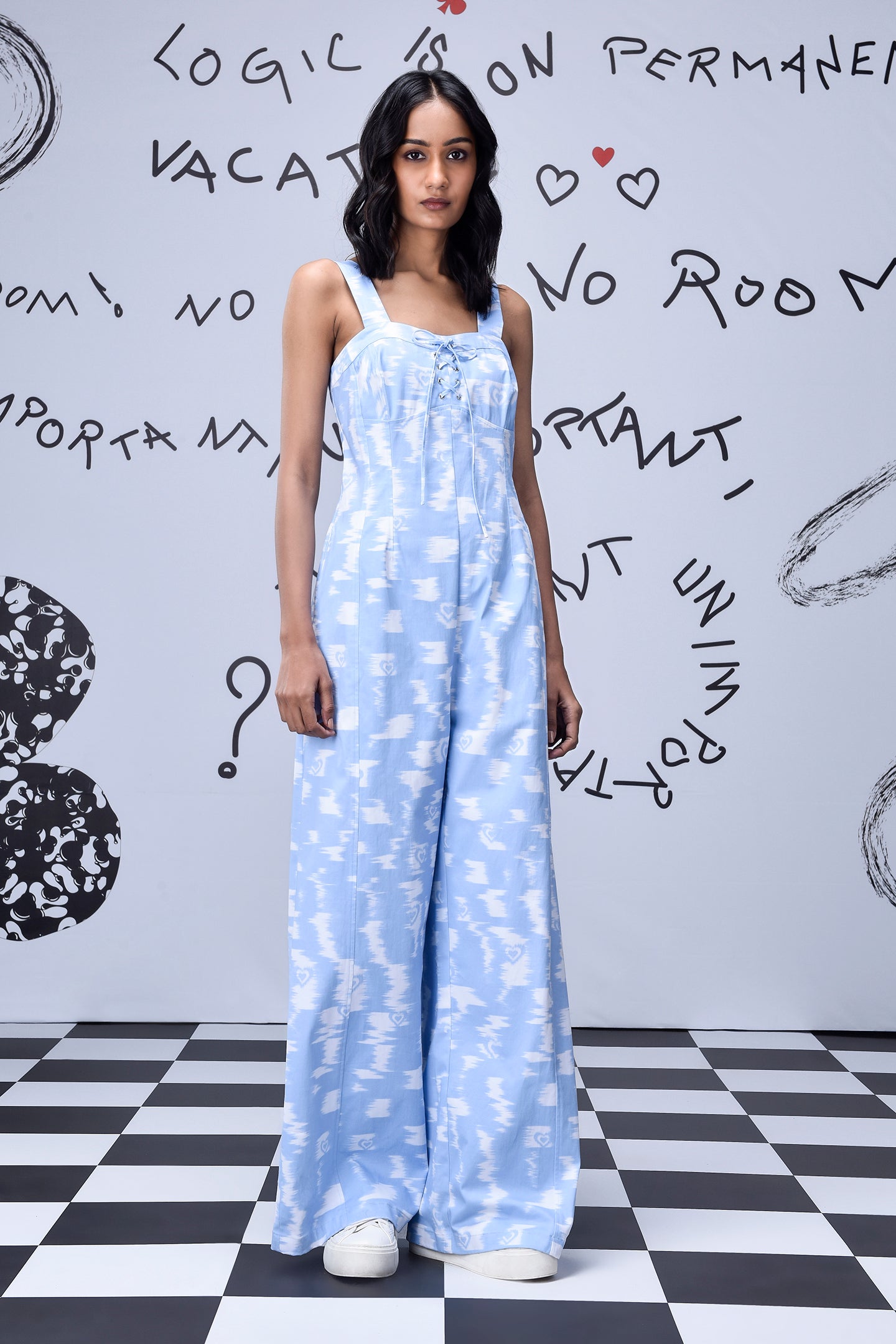 Woman wearing trendy ikat print jumpsuit dungaree by Stylera in light blue and white pattern