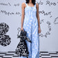 Stylera trendy ikat print jumpsuit in light blue worn by model with black and white backpack