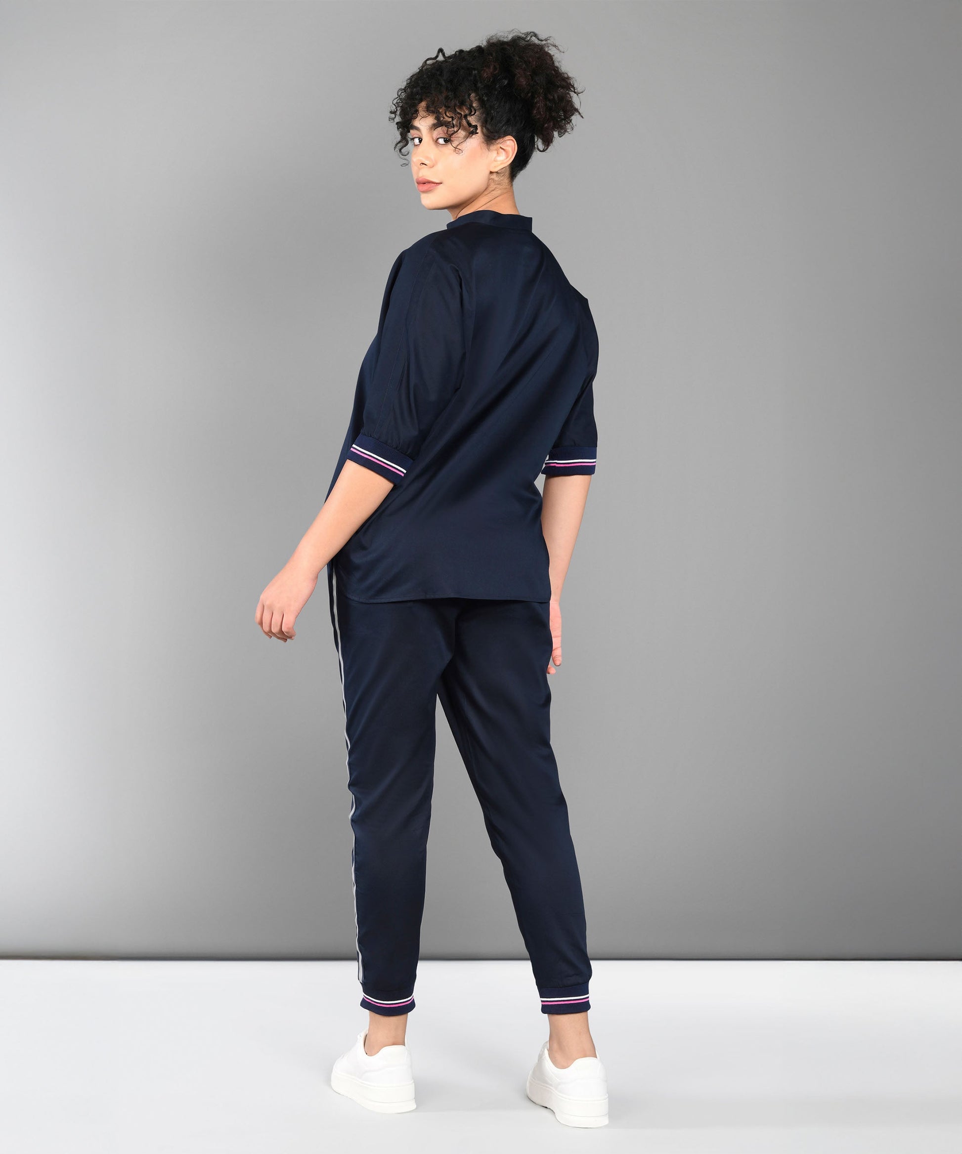 Back view of a woman in a stylish navy tracksuit, showcasing trendy matching outfits for women.