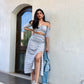 Woman wearing Stylera trendy matching skirt and top co-ord set with off-shoulder crop top and high-slit skirt