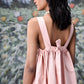 Back view of model in pale pink gathered bow back dress with wide straps trendy maxi dress for women