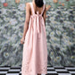 Back view of woman wearing pink bow tie back dress with cutwork hem trendy maxi dress for women on checkered floor