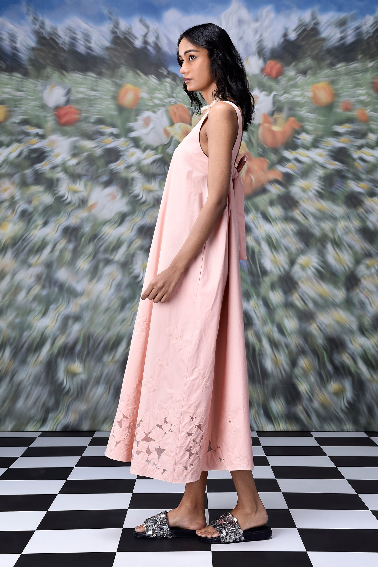 Stylera pink sleeveless A line maxi dress with cutout hem on model on checkered floor trendy maxi dress for women