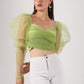 Elegant model wearing a trendy mesh crop top for women in green with puffed sleeves and a fitted design