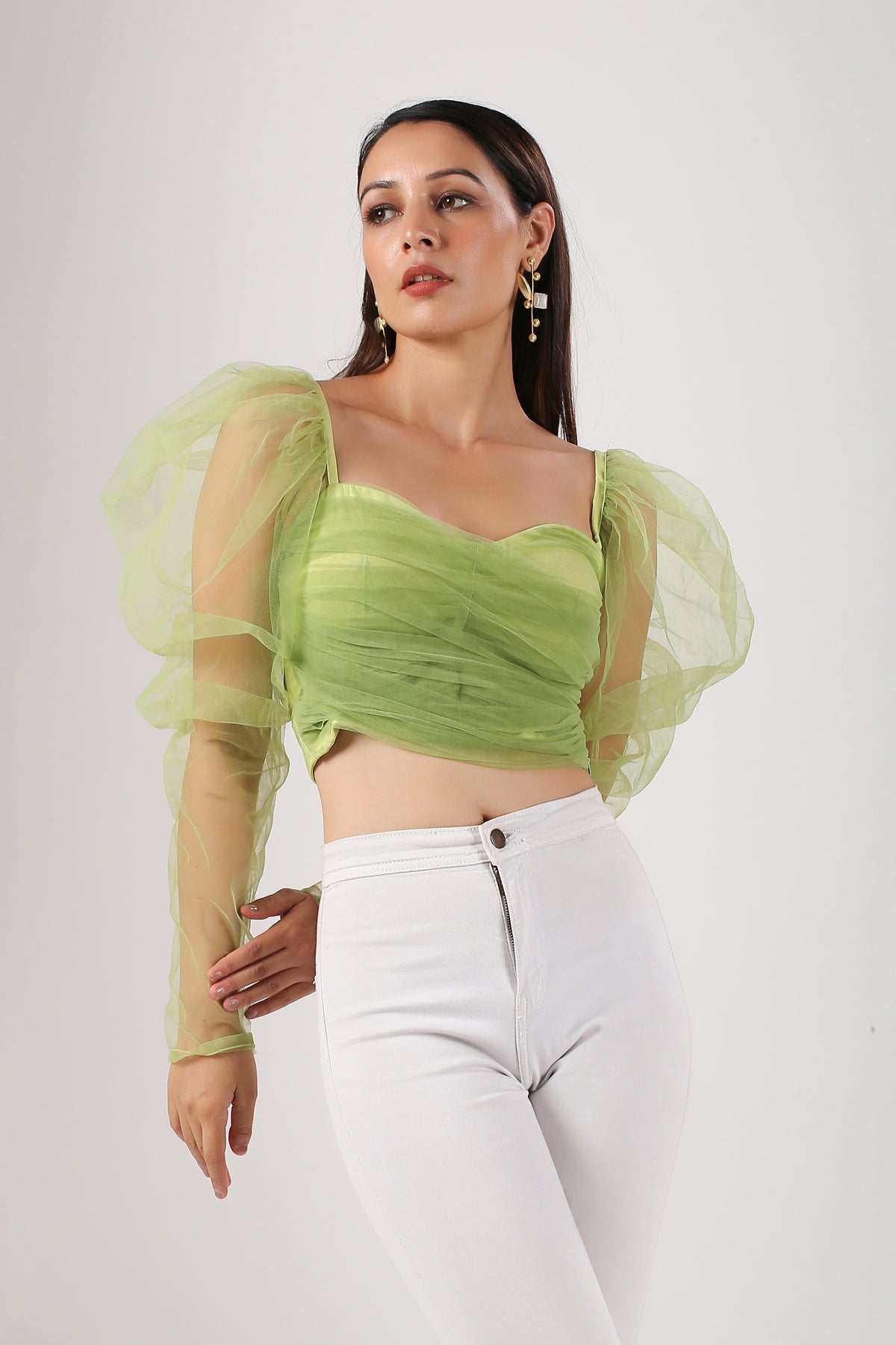 Elegant model wearing a trendy mesh crop top for women in green with puffed sleeves and a fitted design