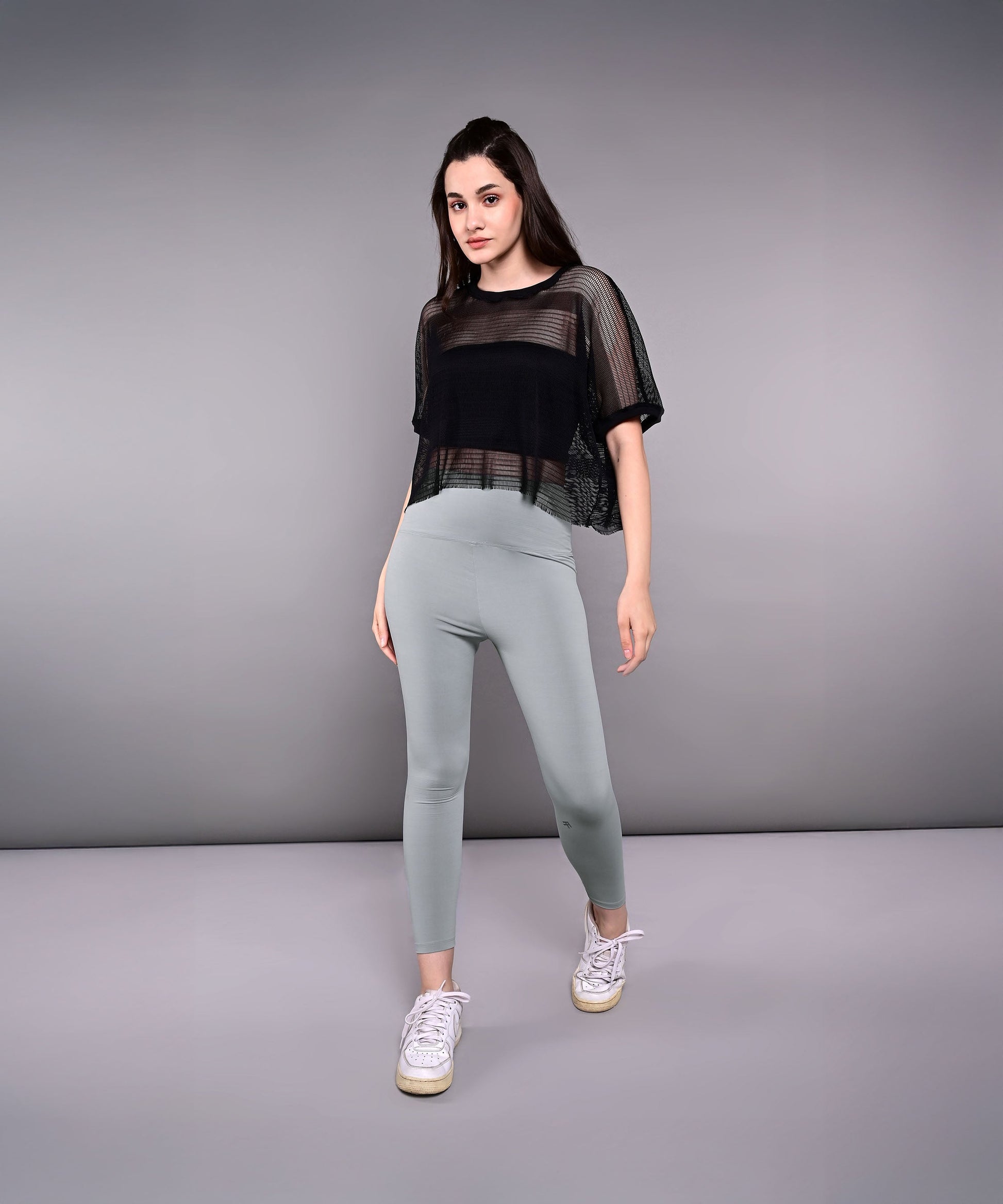 Trendy mesh tops for women in black paired with high-waisted leggings and sneakers