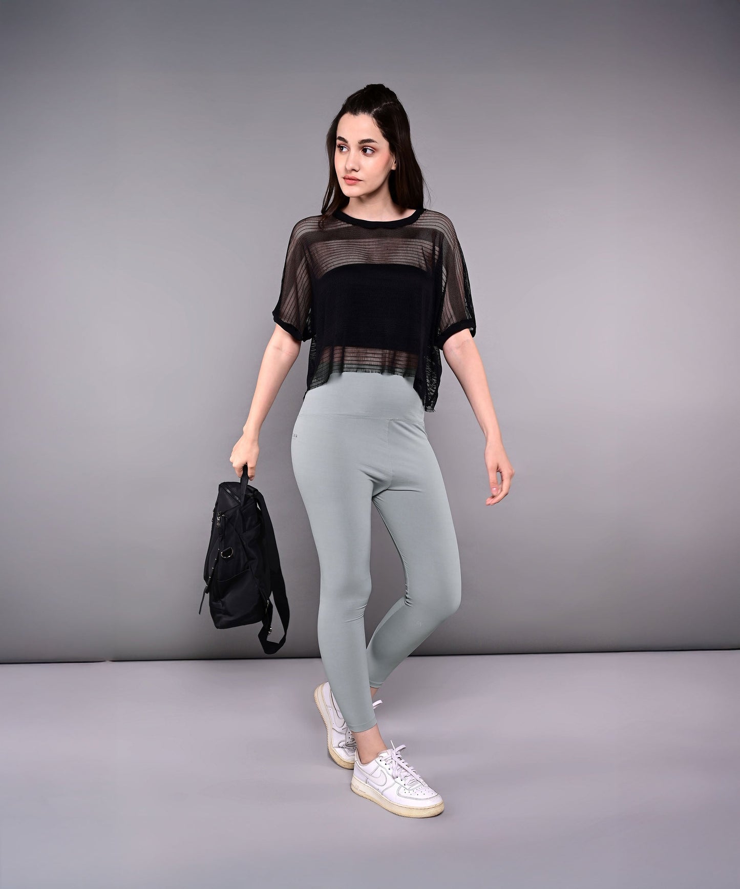 Trendy mesh tops for women in black, paired with light leggings, perfect for casual outings