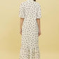 Back view of Stylera white polka dot trendy midi dress for women with ruffle hem and short sleeves