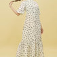 Model wearing Stylera white polka dot trendy midi dress for women with high neck puff sleeves and ruffle hem