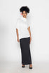 Stylera trendy minimalist women’s top in white paired with a long black skirt