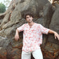 Stylish man in a trendy oversized casual shirt posing on rocky terrain outdoors