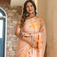Trendy peach saree with floral design draped elegantly on a model in a stylish setting