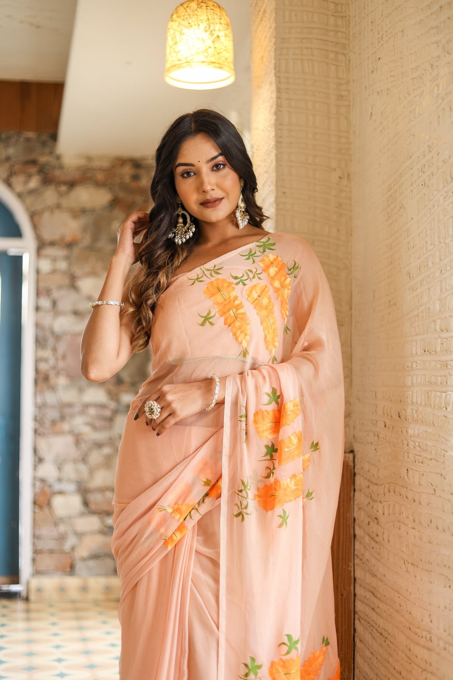 Elegant model wearing a trendy peach saree with floral design, showcasing beautiful embroidery and light fabric