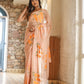 Elegant woman wearing a trendy peach saree with floral design, showcasing vibrant patterns in a stylish setting