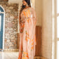 Elegant model wearing a trendy peach saree with floral design, showcasing its vibrant colors and intricate details