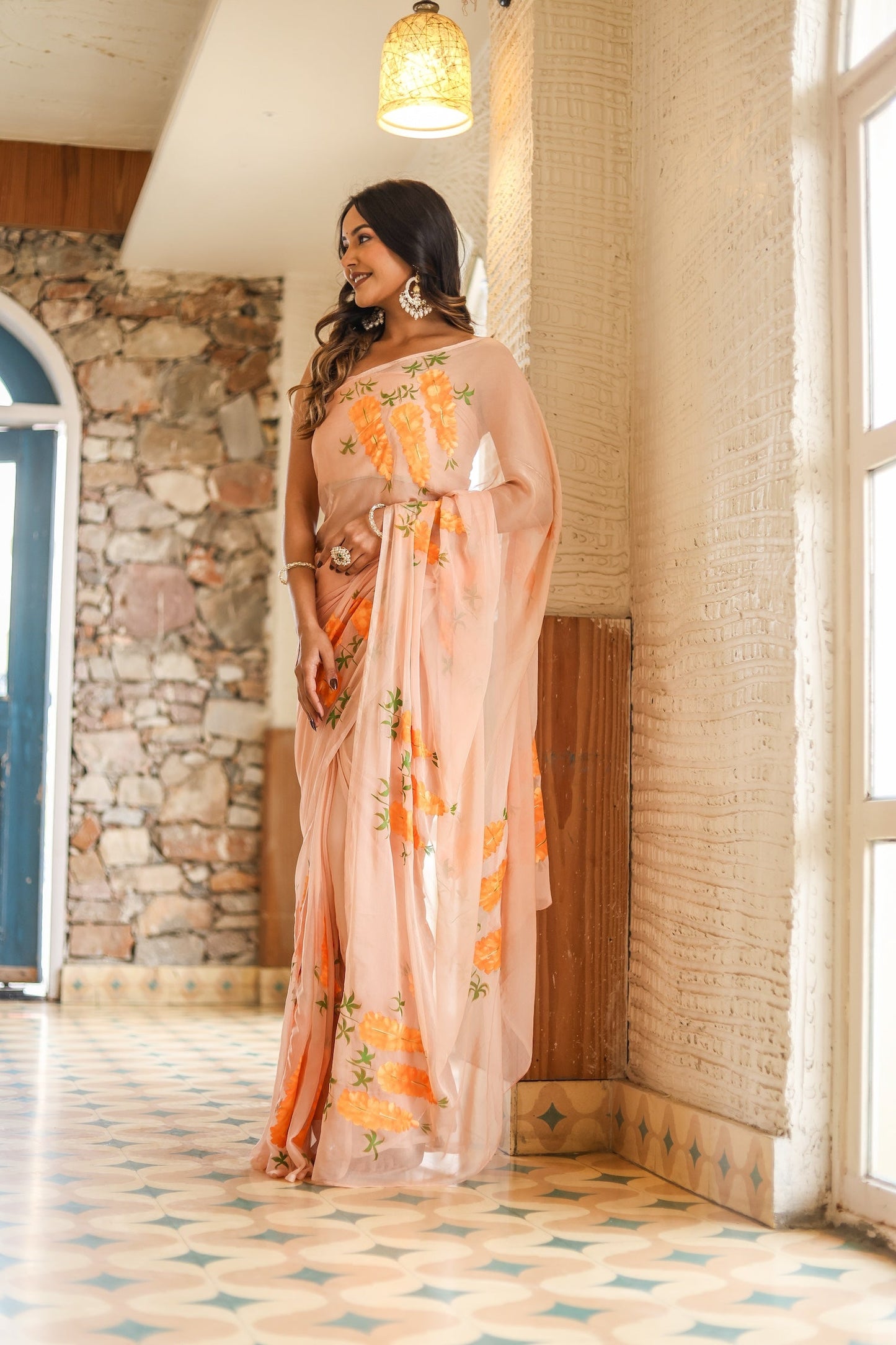 Elegant model wearing a trendy peach saree with floral design, showcasing its vibrant colors and intricate details