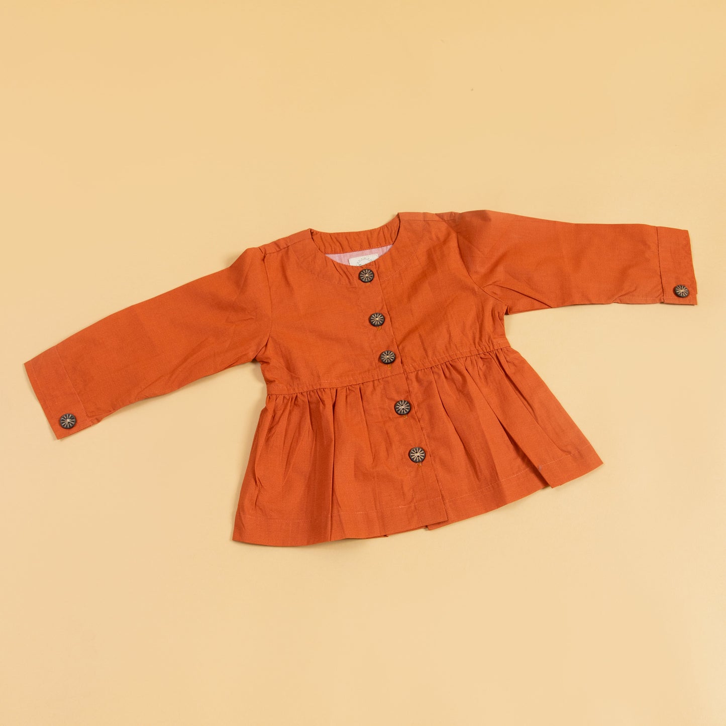 Trendy peplum shirt for women in orange with long sleeves and button details