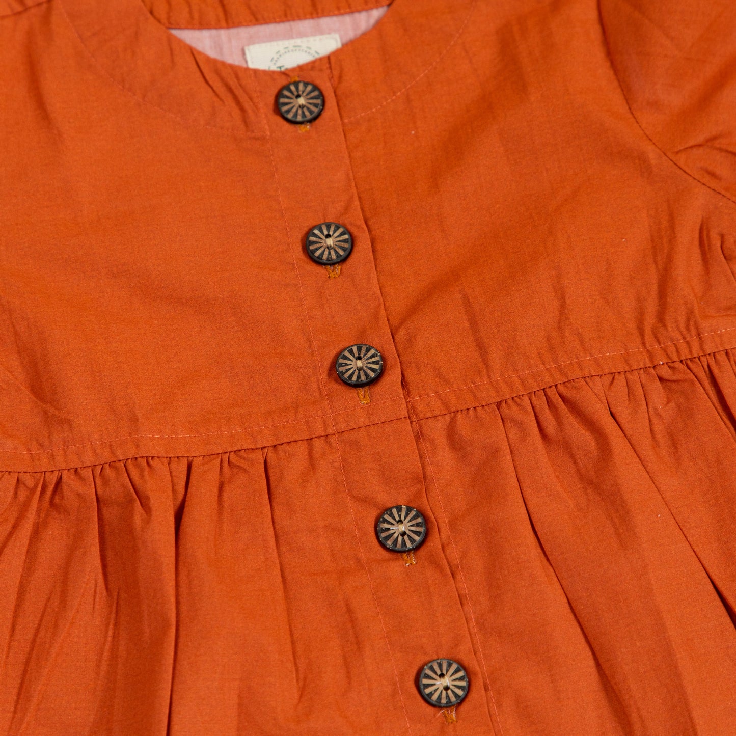 Trendy peplum shirt for women in orange with button detailing and gathered waist for a stylish look