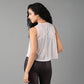 Back view of a woman wearing a trendy sheer crop top for women paired with sleek leggings