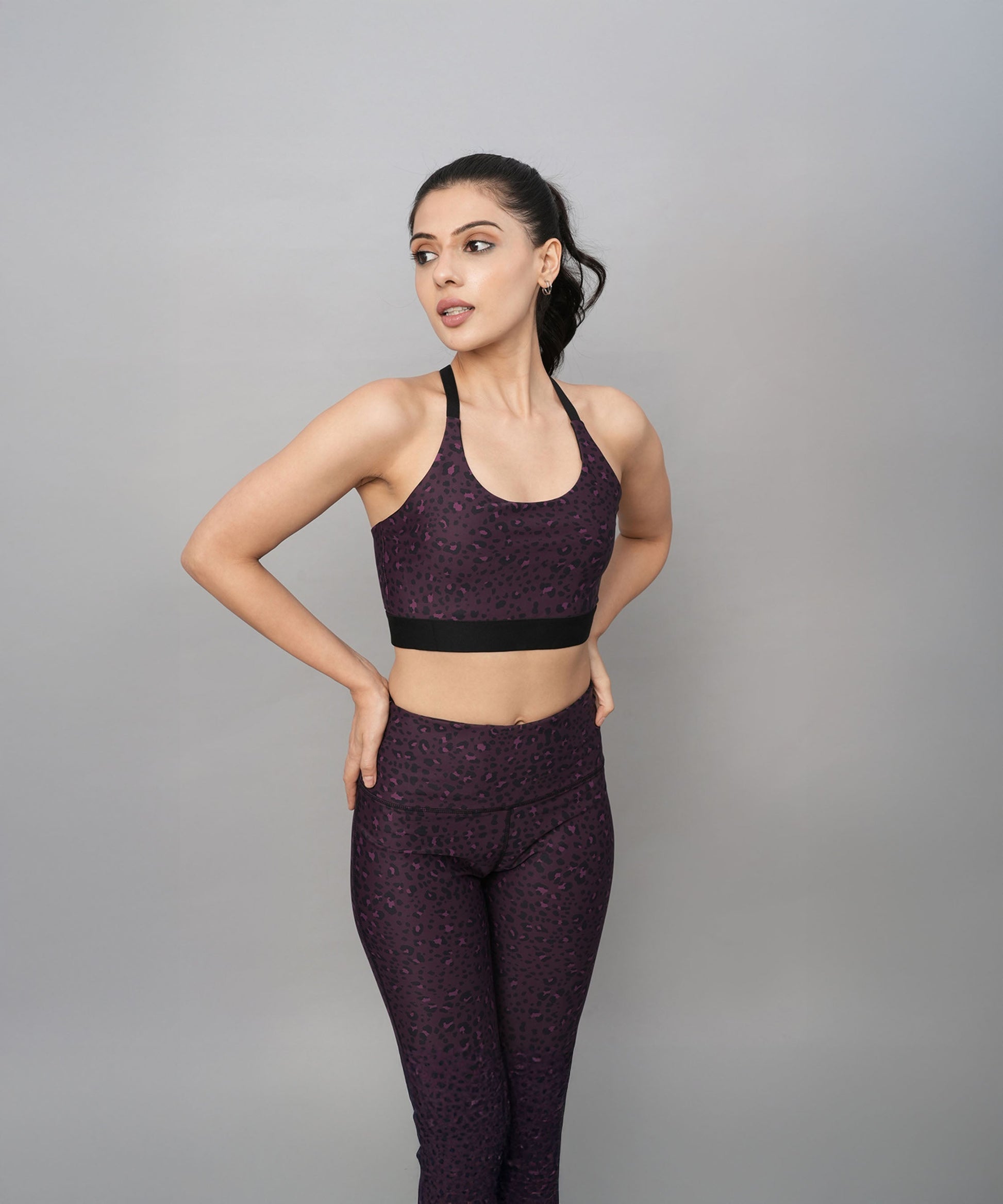 Stylera trendy sports bras with back design in purple worn with matching leggings