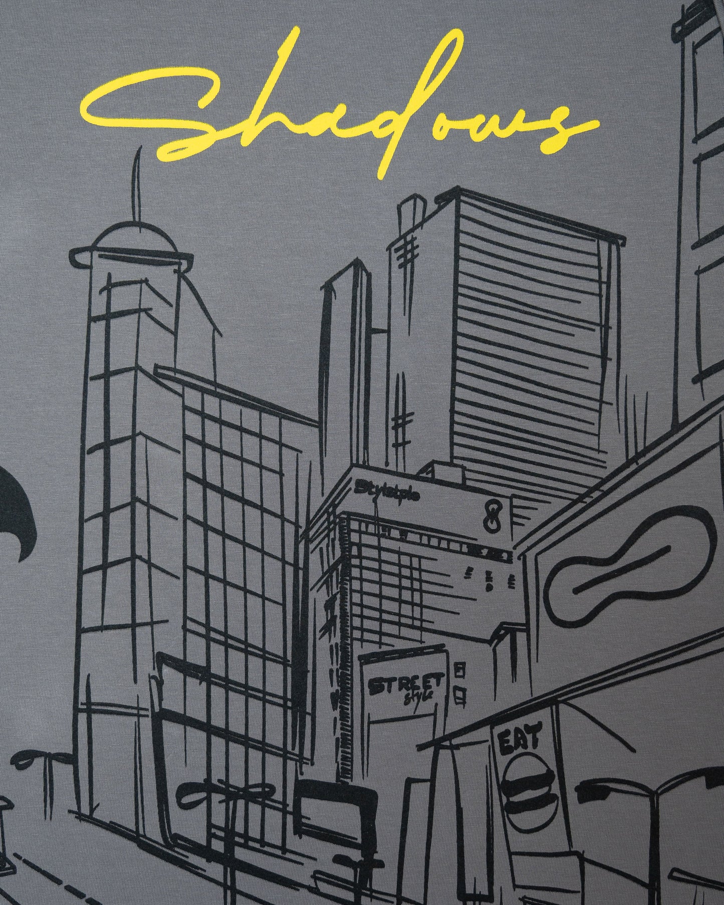 Stylstpls trendy statement oversized t-shirt with artistic cityscape design and yellow 'Shadows' text