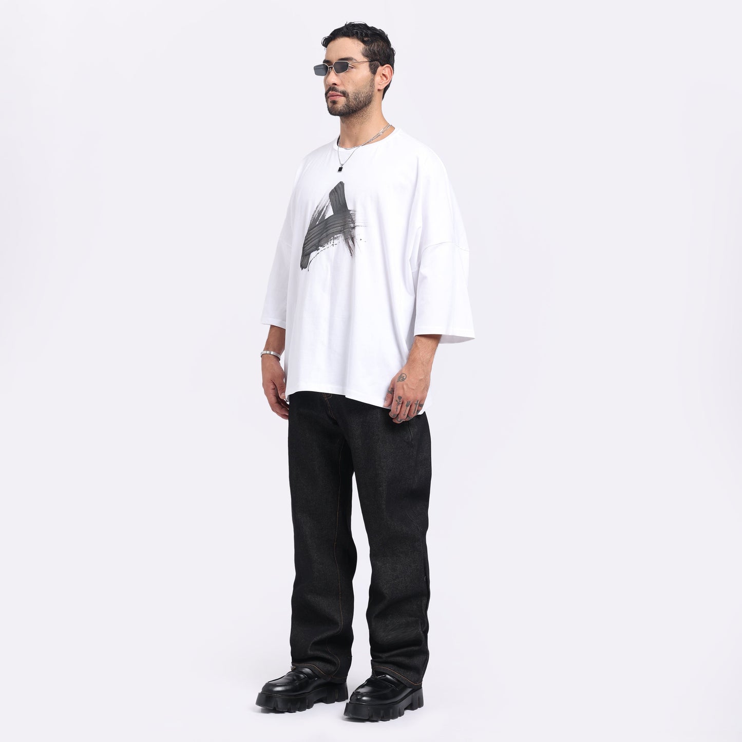 Stylera trendy streetwear t-shirt men in white with graphic design, styled with black pants and accessories