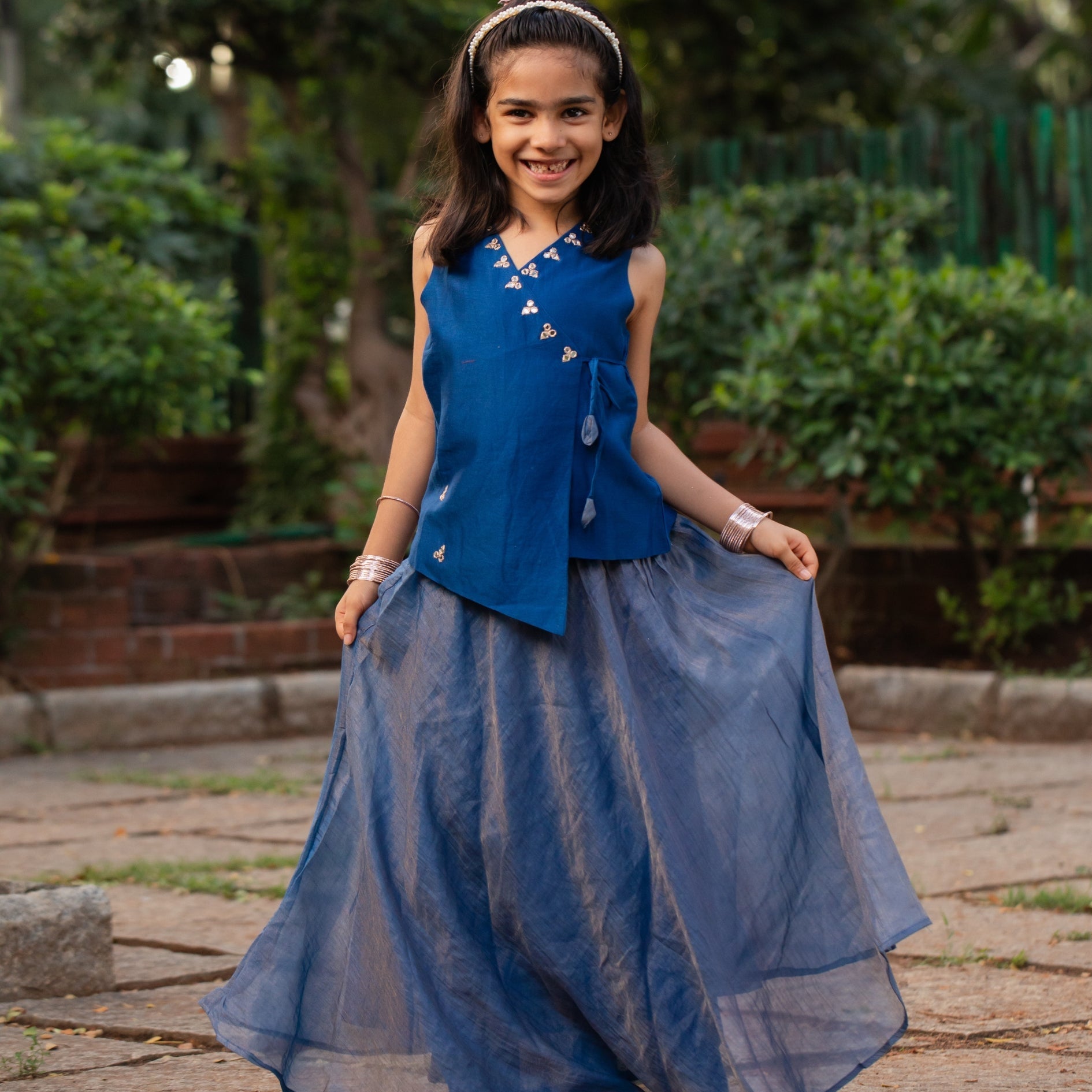 Adorable girl wearing a blue trendy traditional outfit for girls with stylish skirt and decorative buttons