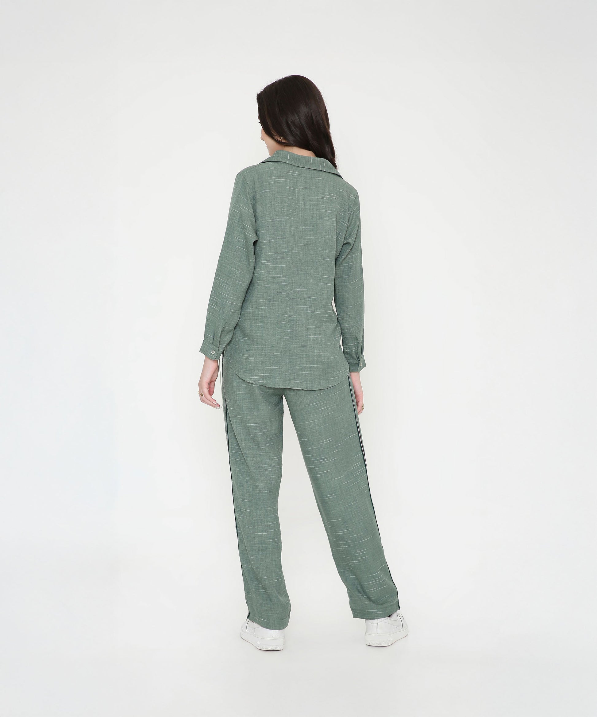 Back view of a stylish woman in a trendy two piece cord set in green, perfect for casual outings
