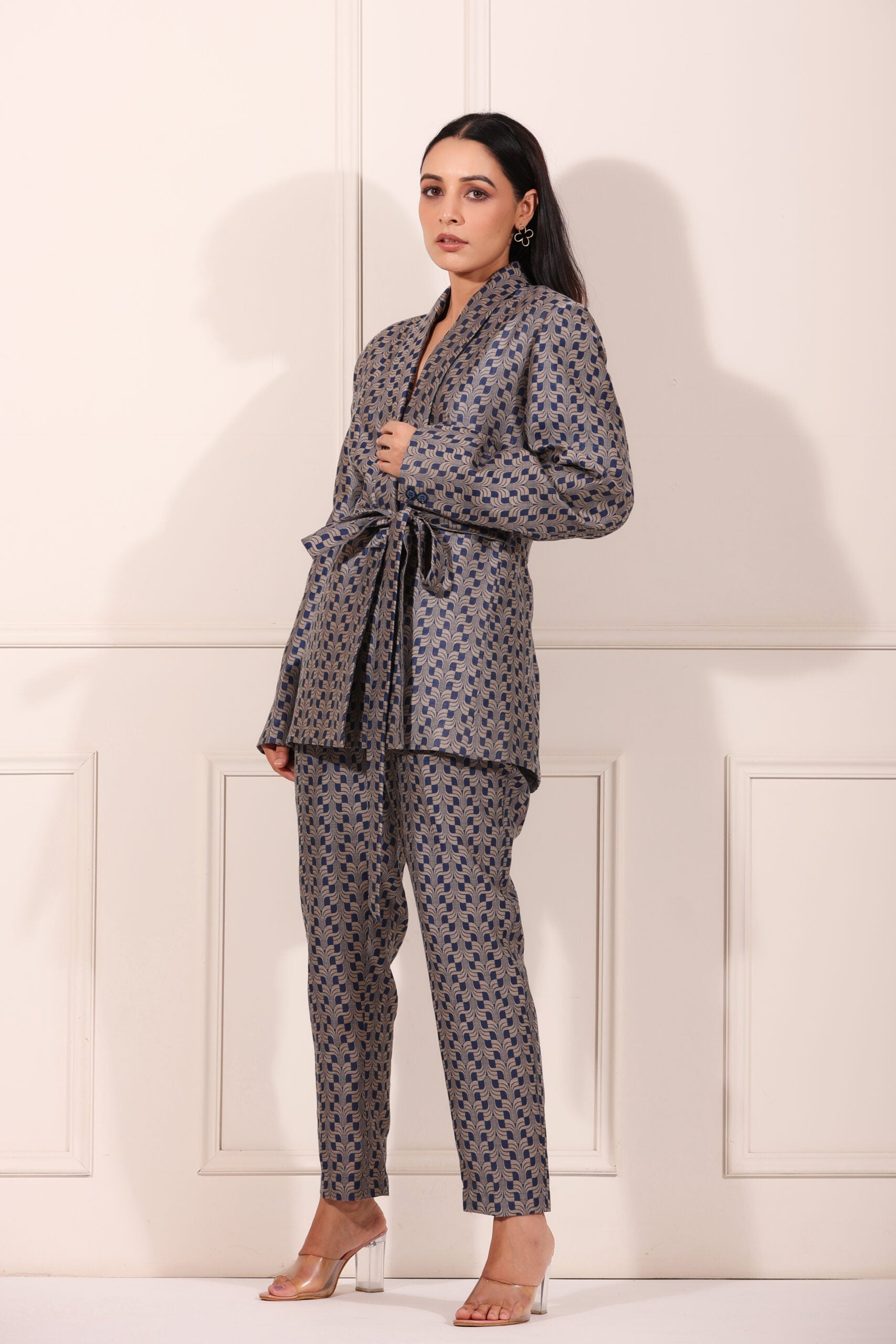 Trendy two piece pant suit women in blue and gray geometric pattern with a belted jacket and fitted pants