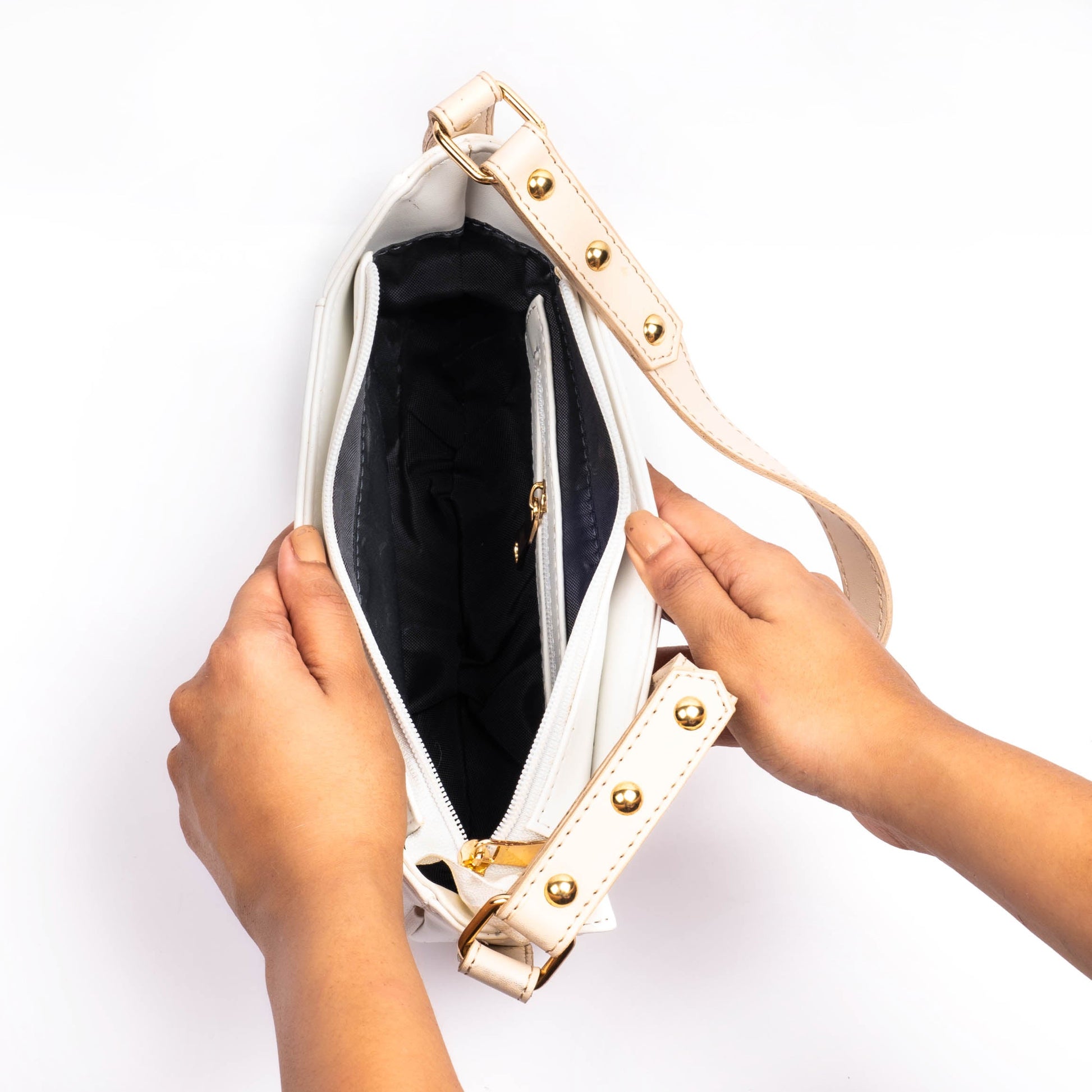 Inside view of a trendy white leather purse with a zippered compartment and stylish gold hardware