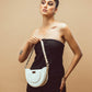 Trendy white leather purse showcased on a model wearing a black outfit, ideal for stylish outings