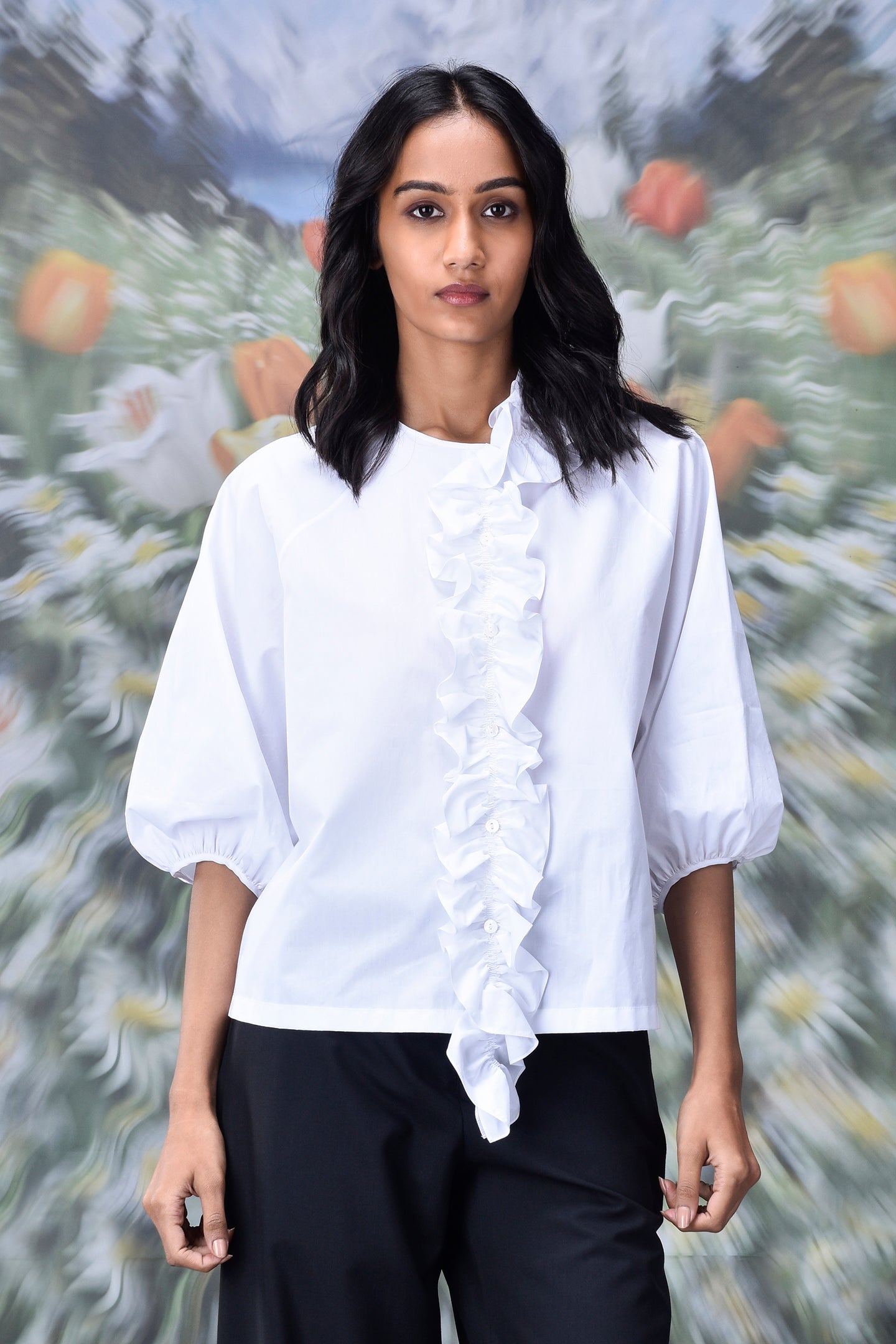 Stylera woman wearing ruffle front white top with puff sleeves paired with black pants trendy white tops for ladies